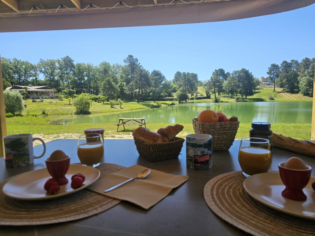 Petit-déjeuner sur la terrasse d’un mobil-home Premium face à l’étang